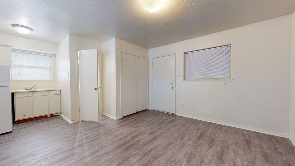 A room with a kitchenette and a window.