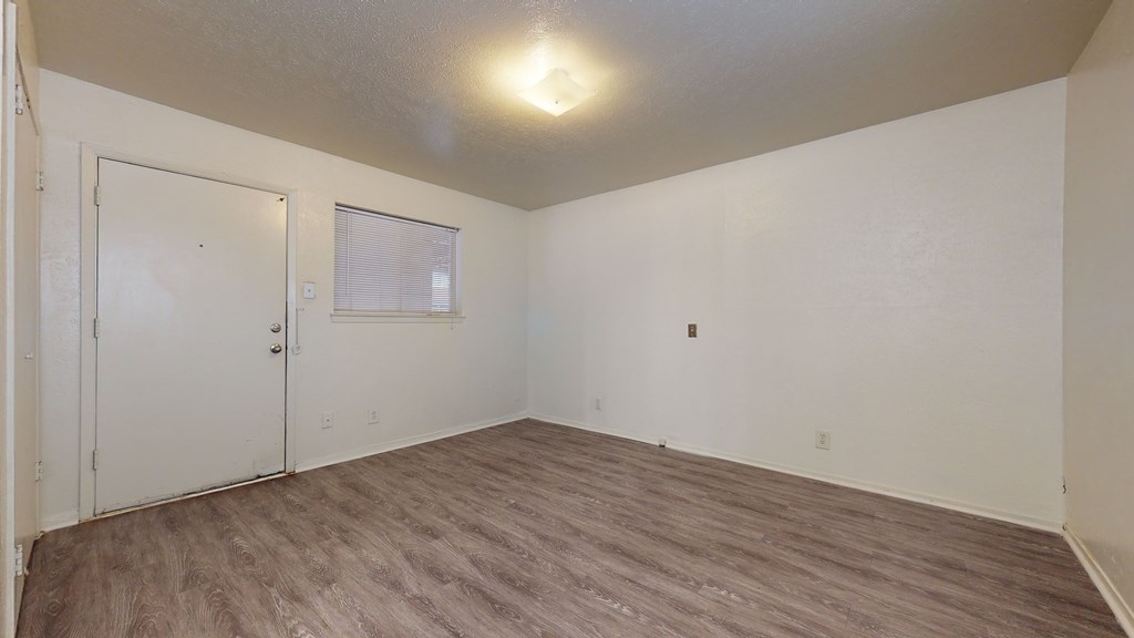 A room with a white door and a window with blinds.