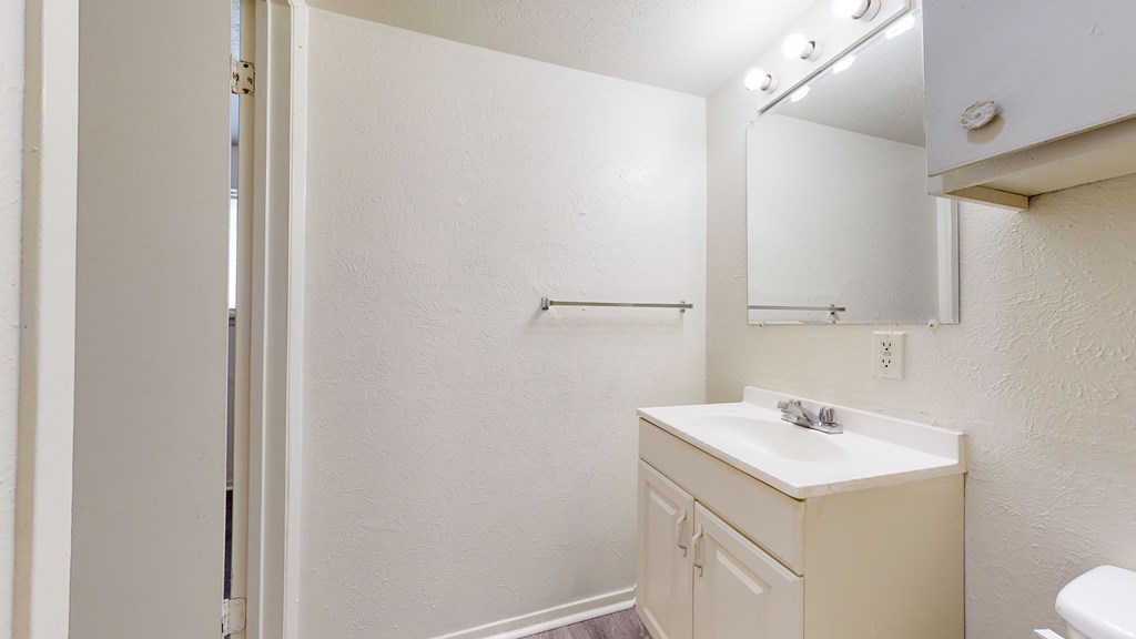 A white bathroom with a toilet, sink, and towel rack.