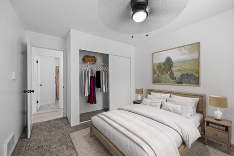 A bedroom with a large bed and a painting on the wall.