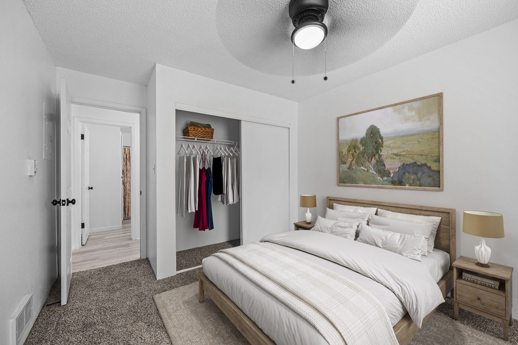 A bedroom with a large bed and a painting on the wall.
