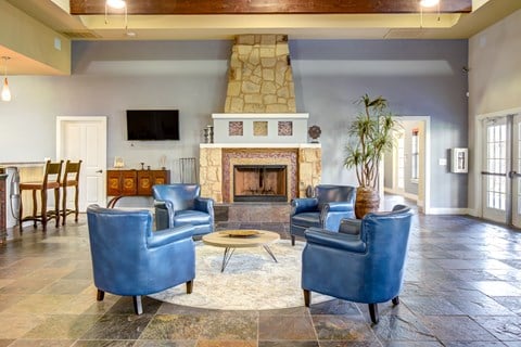 a living room with blue chairs and a fireplace