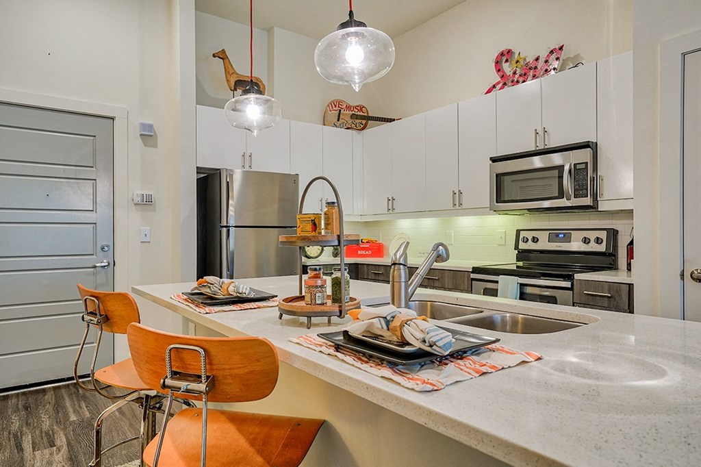 a kitchen with white cabinets and stainless steel appliances