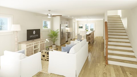 A living room with a white couch and a wooden staircase.