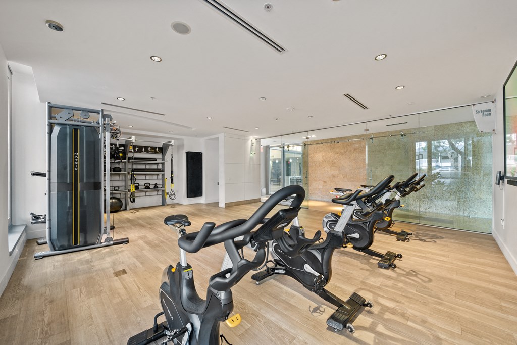 two treadmills in a gym with a glass wall and a yoga studio