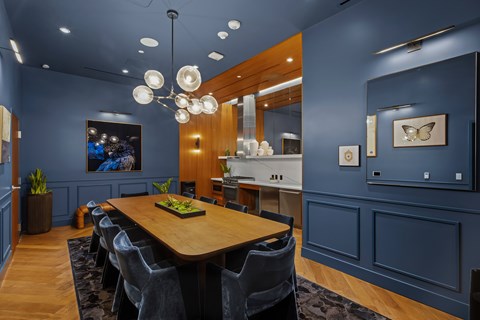 A modern dining room with a wooden table and grey chairs.