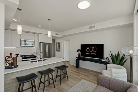A modern kitchen with a bar stool and a sign that says 800 Broadway.