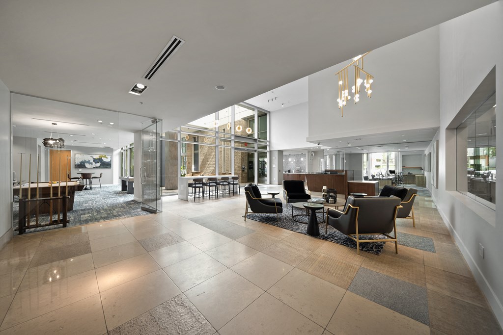 a large lobby with chairs and tables and glass walls