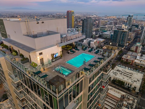 A high rise building with a pool on the roof.
