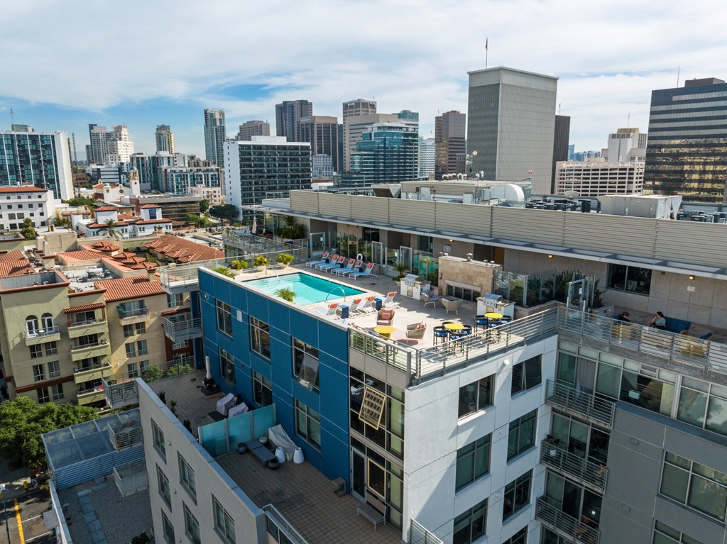 a pool on the roof of a building with a city in the background
