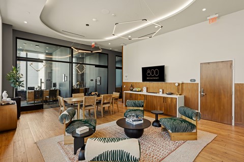A modern living room with a glass wall and a wooden floor.