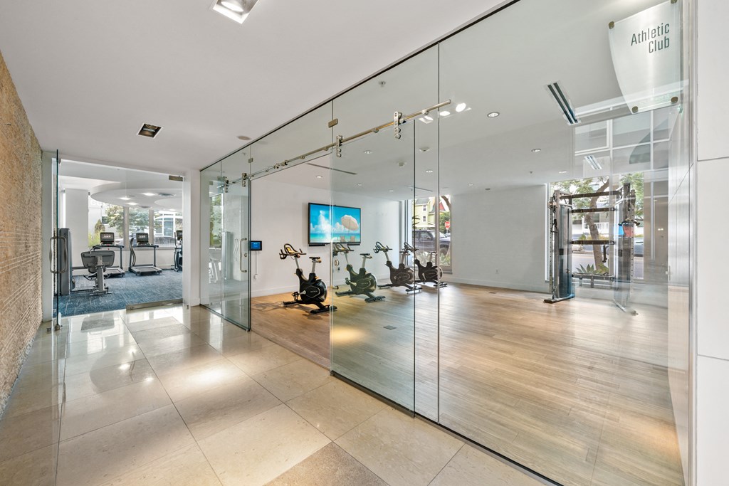 a large lobby with glass walls and a tv on the wall