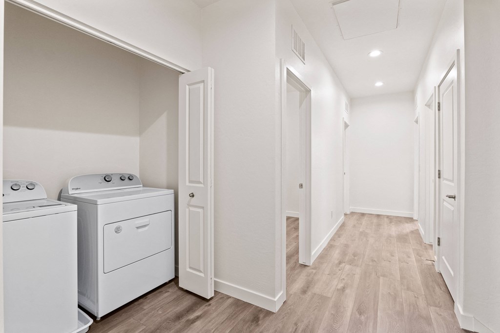 the living room and laundry room of a manufactured home with washer and dryer