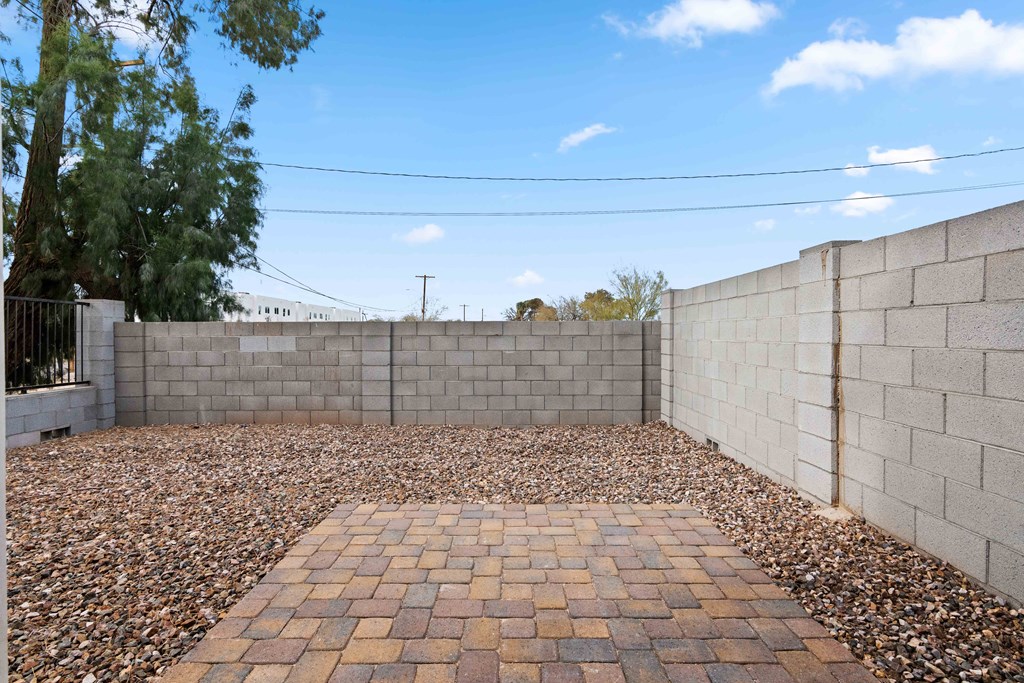a backyard with a retaining wall and gravel