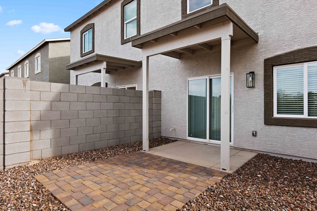 the front entrance of a house with a stone wall and a patio