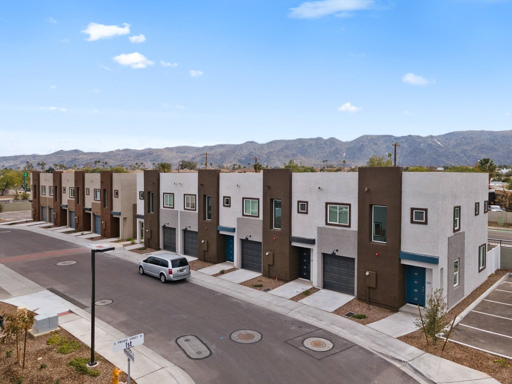 a row of apartment buildings with a car parked in front of them
