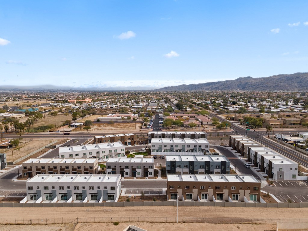an aerial view of a city with buildings and mountains in the background