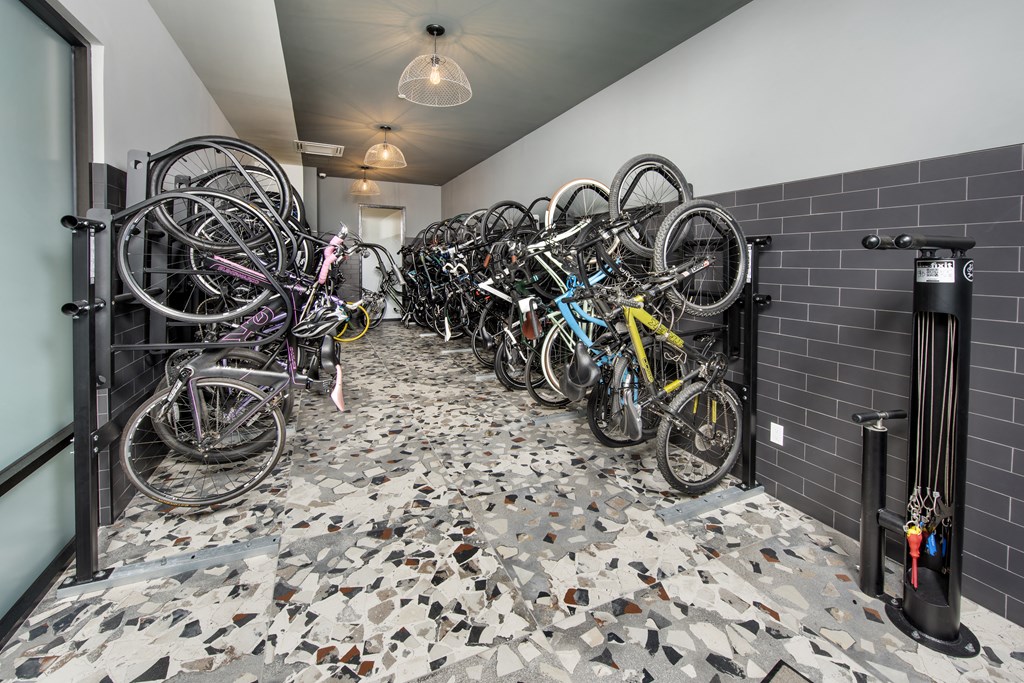 a row of bikes parked in a room with black tiles