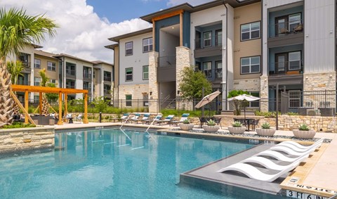A swimming pool in front of apartment buildings.