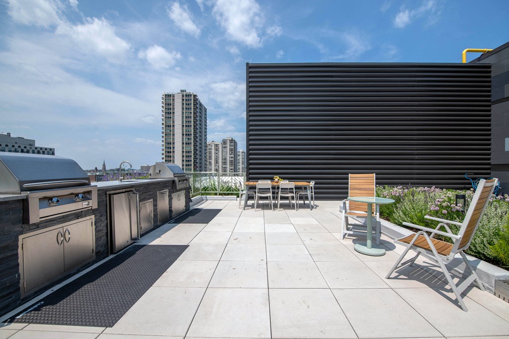 A rooftop patio with chairs and a table.