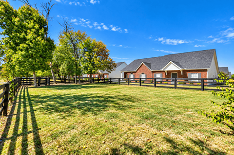 A house with a fence and trees in front of it.
