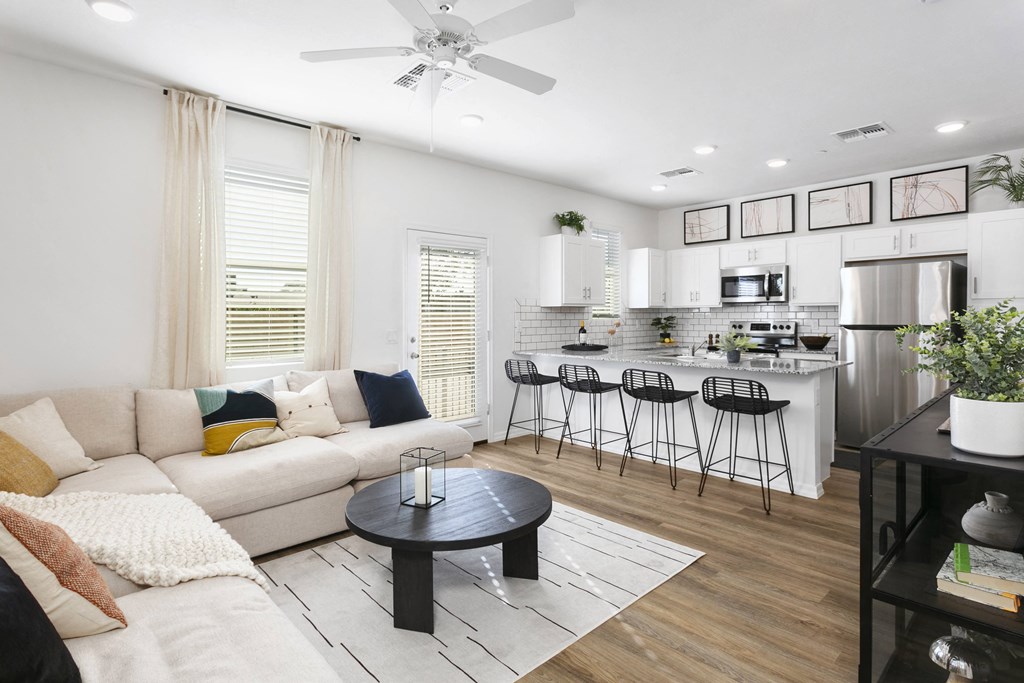 a living room with a couch and a table in front of a kitchen