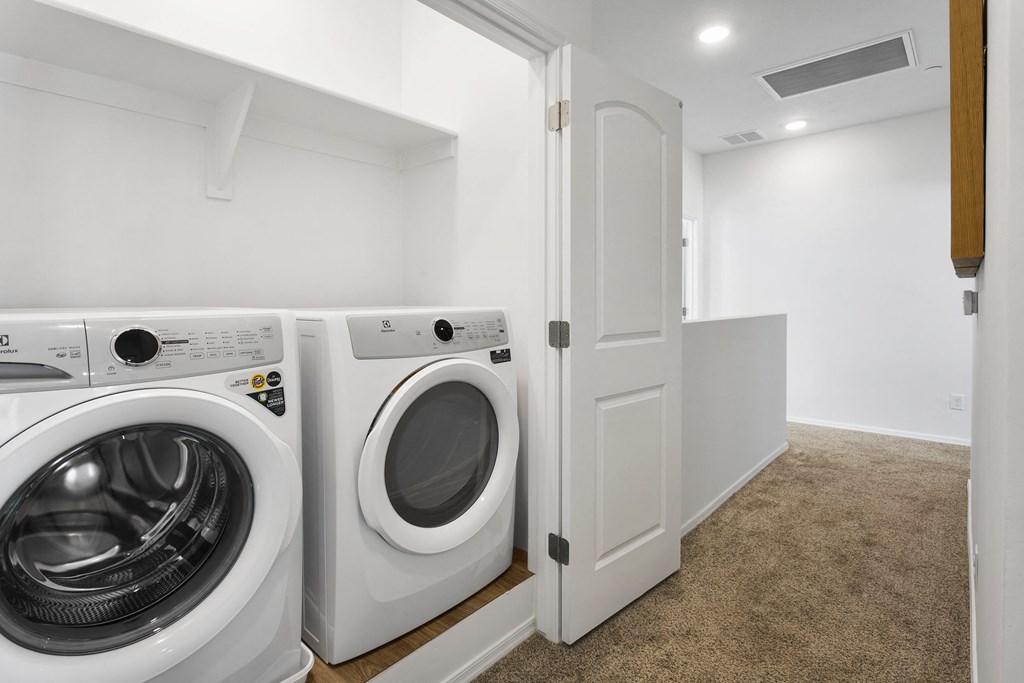 a washer and dryer in a laundry room with a white door