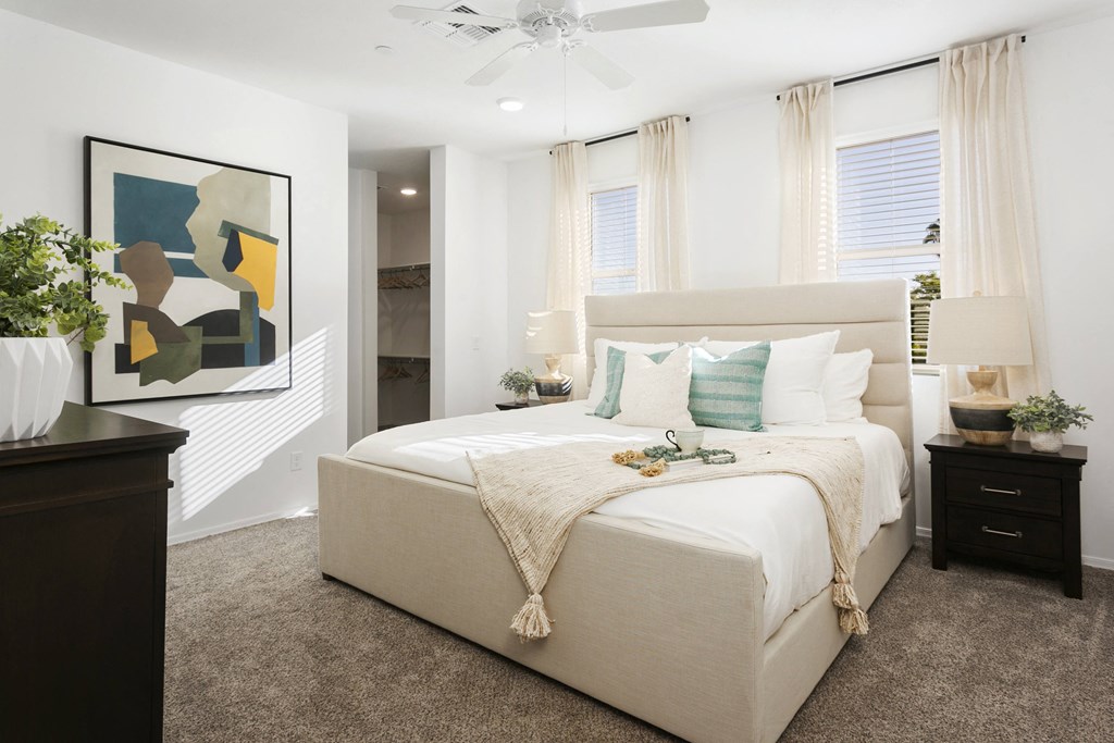 a bedroom with a white bed and a painting on the wall