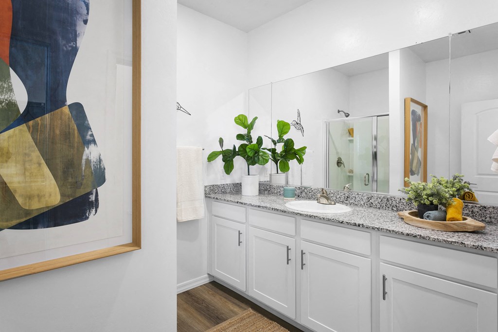 a bathroom with white cabinets and a sink and a mirror