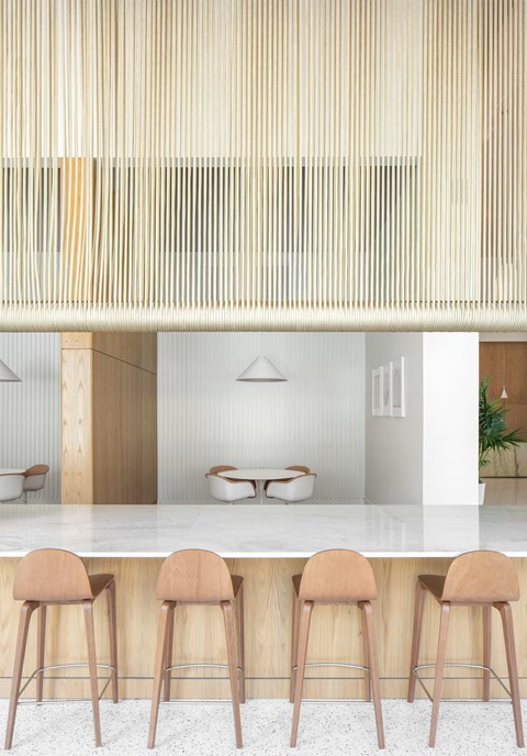A kitchen with a bar counter and three stools.