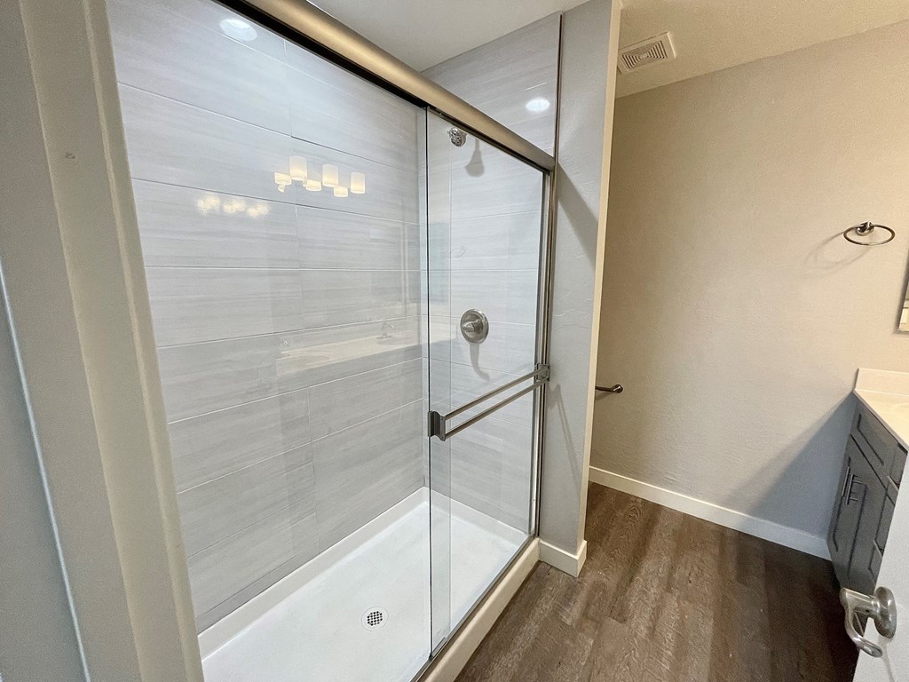 a walk in shower in a bathroom with a glass door
