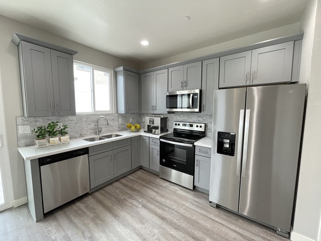 a kitchen with stainless steel appliances and gray cabinets
