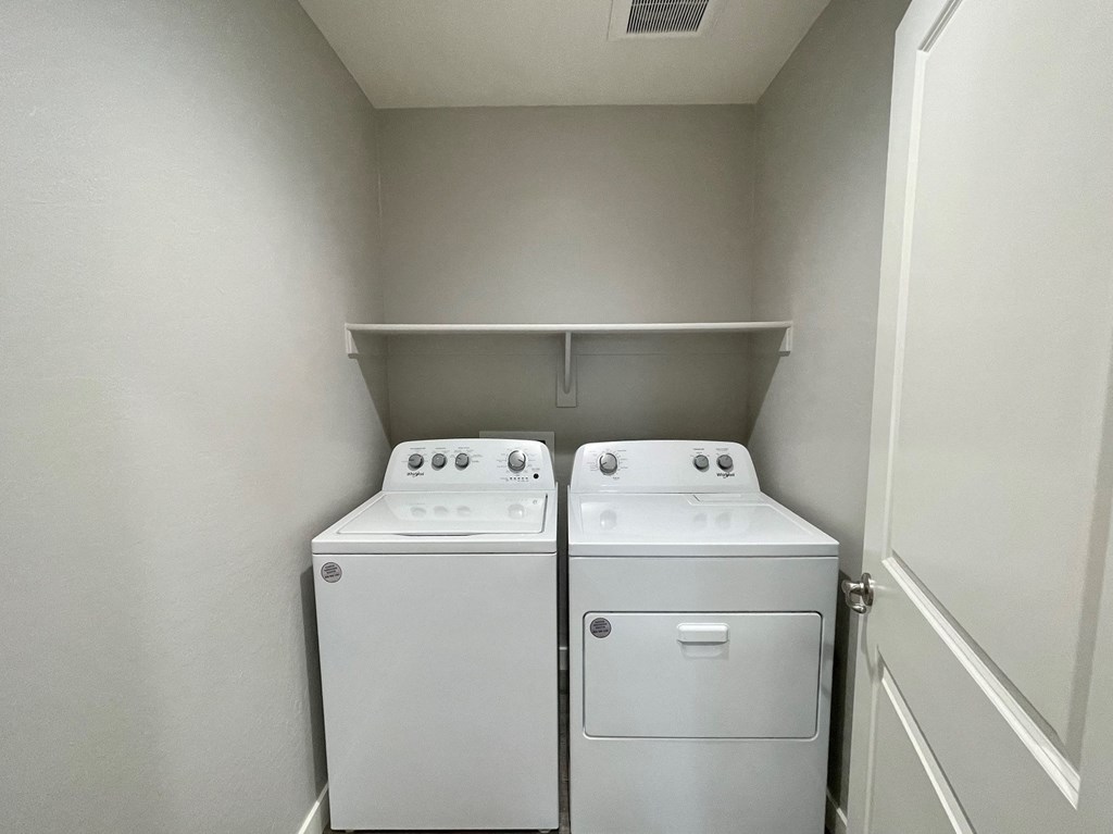 an empty laundry room with two washes and a dryer