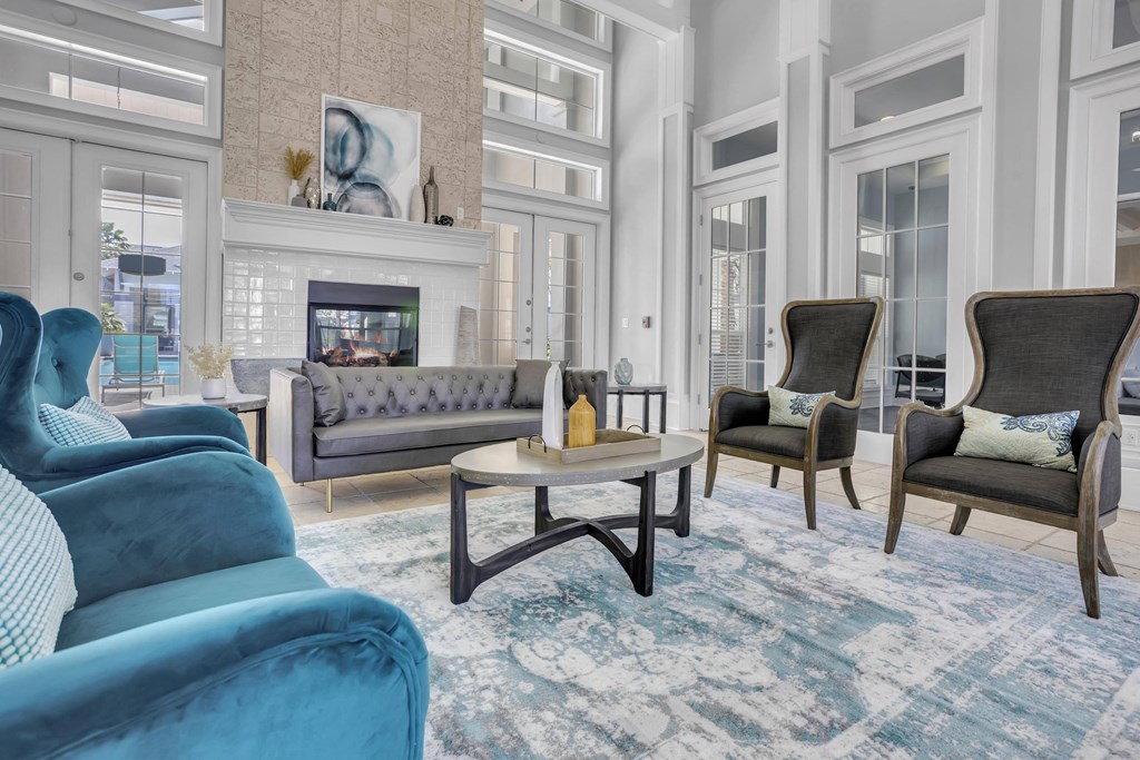 a living room with blue couches and chairs and a fireplace