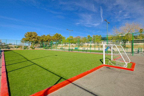 a soccer field with green grass and a red border around it