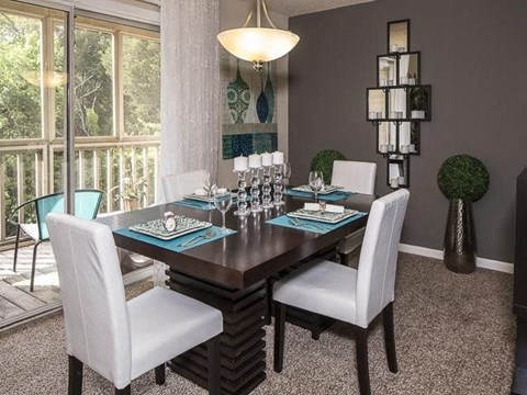 a dining room with a wooden table and chairs