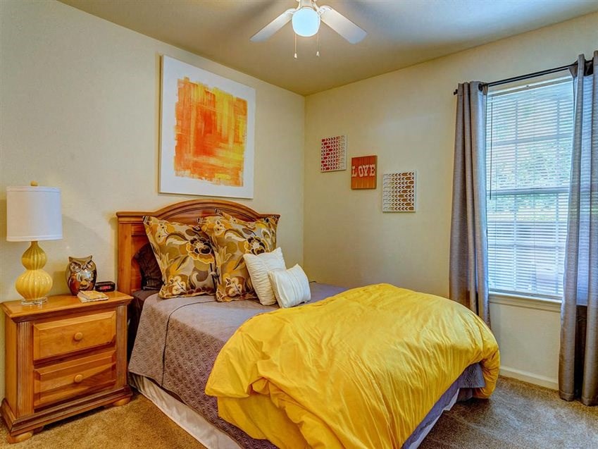a bedroom with a bed and a ceiling fan