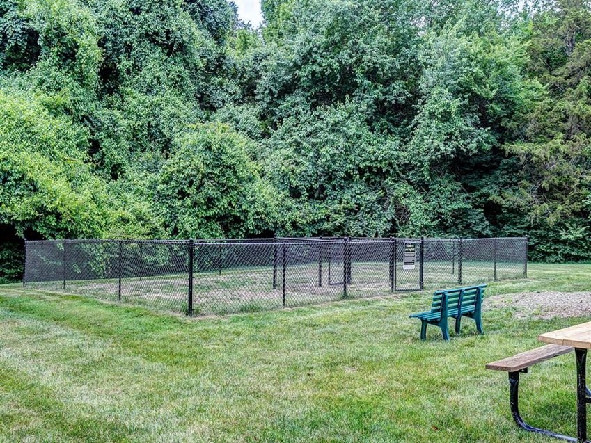 a park bench in the grass next to a fence