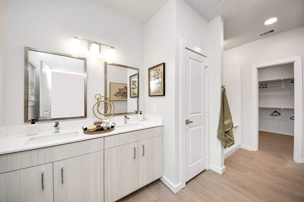 A bathroom with a white vanity and a large mirror.