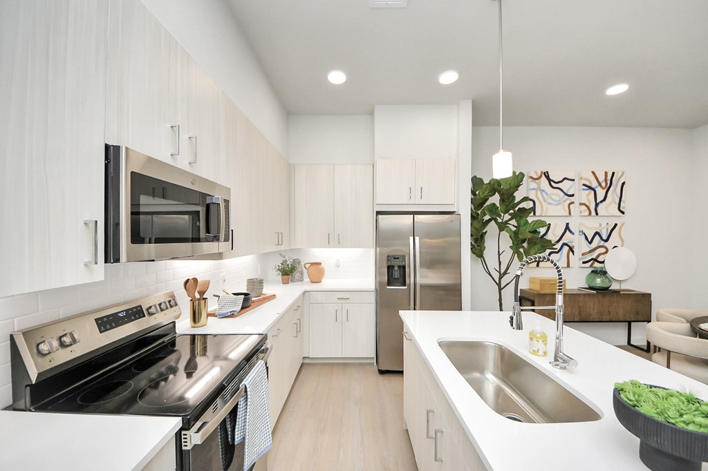 A modern kitchen with stainless steel appliances and white cabinetry.