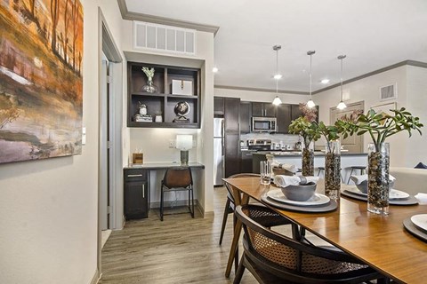 A modern kitchen with a dining table set for two.