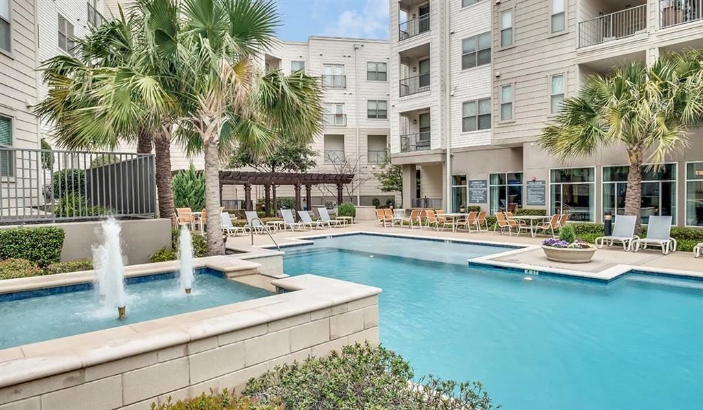 a large swimming pool next to an apartment building