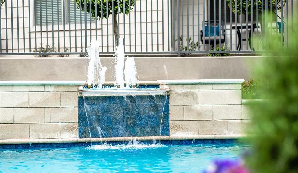 a water fountain in the middle of a swimming pool