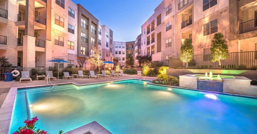 an apartment swimming pool in front of an apartment building
