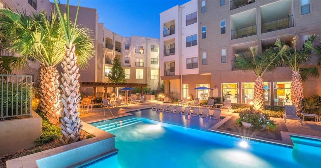 an apartment building with a swimming pool and palm trees