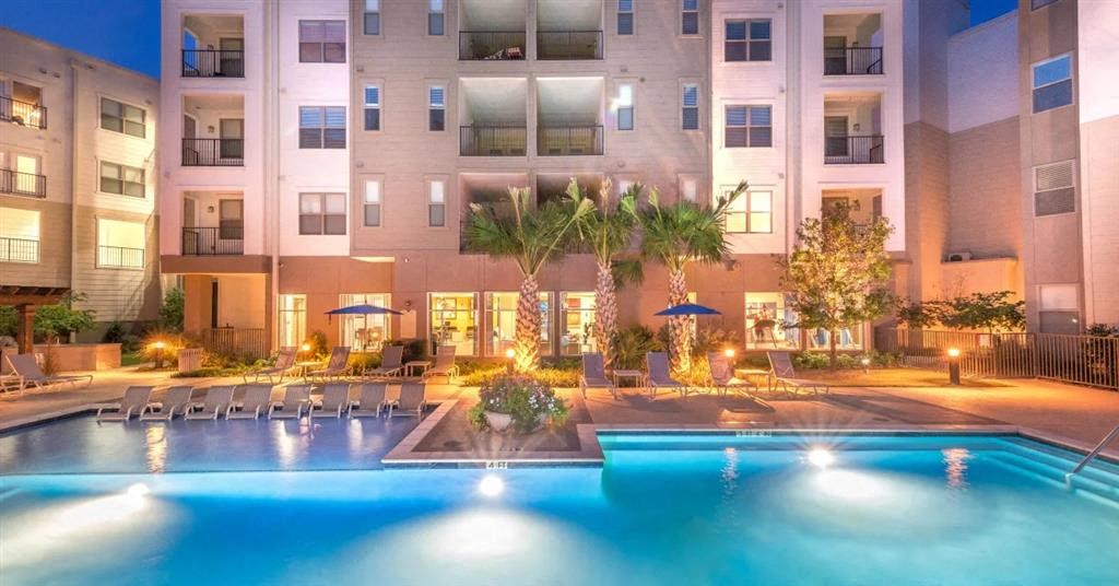 a large swimming pool in front of an apartment building