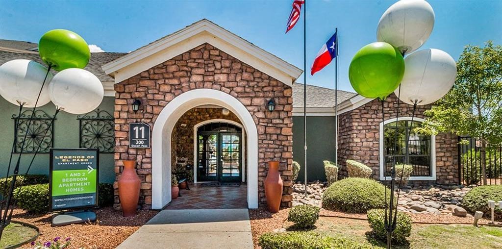 the front entrance of a brick building with balloons and flags