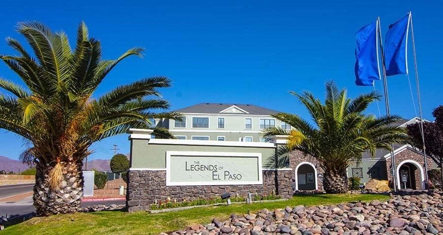 a large building with palm trees and flags in front of it