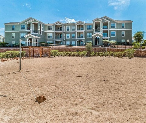 an empty volleyball court in front of an apartment building