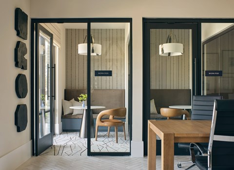 A modern dining area with a wooden table and chairs.